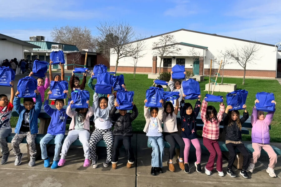 Children holding bags outside